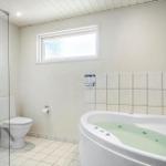 Bad mit Whirlpool, Toilette und Dusche hinter Glas