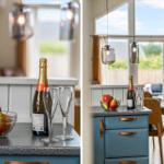 Küchenbereich mit Obstschale, Sekt und Gläsern. Große Fenster mit Blick auf Garten.