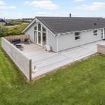 Moderne Ferienhaus mit großer Terrasse, Garten und Außensitzgelegenheiten.