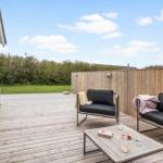 Terrasse mit Sitzgruppe, Tisch und Blick auf Grünfläche.
