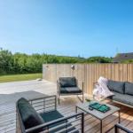 Terrasse mit Sitzgruppe, Tisch und Blick auf Grünfläche.