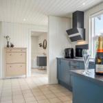 Küche mit Blick auf Bad. Auf der Arbeitsplatte steht eine Champagnerflasche.