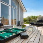 Backgammon auf Terrasse mit Sitzgelegenheiten und Blick auf Haus.