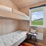 Zimmer mit Doppelstockbett, Fenster und Stuhl