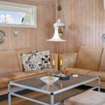 Zwei Sofas mit Kissen, Glas-Tisch und Holzwand im Wohnzimmer.