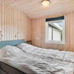 Schlafzimmer mit Holzwand, Bett und Fenster