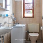 Badezimmer mit Waschmaschine, Toilette und Fenster.