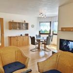 Wohnzimmer mit Essbereich, Fernseher und Holzmöbel.