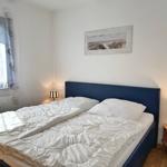 Schlafzimmer mit Doppelbett, zwei Nachttischen und Wandbild.