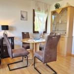 Essbereich mit runden Tisch, vier Stühlen und Glasvitrine.