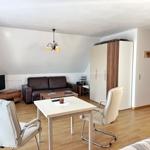 Wohnzimmer mit Sofa, Esstisch und Schrank