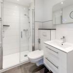 Badezimmer mit Dusche, Toilette und Waschbecken.