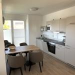 Küche mit Essbereich und Balkontür. Moderne Einbauküche mit Küchenschränken.