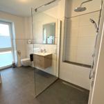 Moderne Badezimmer mit Dusche, Waschbecken und Toilette.