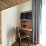 Schreibtisch mit Fernseher und Stuhl an Wand