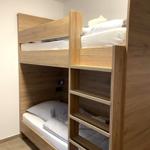Holz-Etagenbett mit Schlafcouch und integriertem Treppenaufgang.