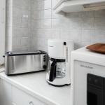 Küchenzeile mit Toaster, Kaffeemaschine und Mikrowelle. Fenster mit Blick auf Garten.