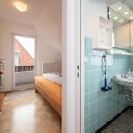 Schlafzimmer mit Balkon und angrenzende Bad mit Waschbecken