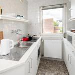 Küche mit Spüle, Herd, Kühlschrank und Fenster.