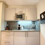 Küche mit Mikrowelle, Spüle und Küchenzeile