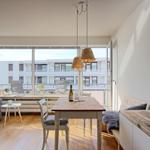 Wohn- und Essbereich mit Tisch, Stühlen und Balkonansicht.