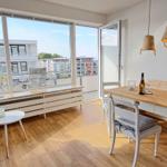 Wohnbereich mit Essbereich, Balkon und großen Fenstern.