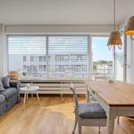 Wohn- und Essbereich mit Sofa, Tisch und Fenster zur Terrasse.