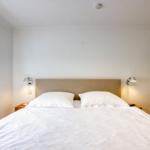 Ein Schlafzimmer mit Doppelbett, zwei Nachttischen und einer Fensterbank.