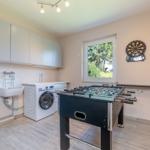 Wohnraum mit Tischfußball, Dartscheibe und Waschmaschine.