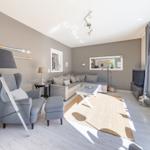 Wohnzimmer mit Sofa, Sessel und Tisch auf Teppich