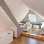 Zwei Schlafplätze unter Dachschrägen mit Dachfenster und Holzboden.