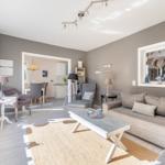 Wohnzimmer mit Sofa, Couchtisch und Blick in die Küche.