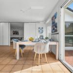 Esszimmer mit Tisch, Stühlen und Blick auf Terrasse.