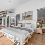 Schlafzimmer mit Bett auf Paletten, Schlafzimmer mit Blick auf Terrasse und Wohnbereich.