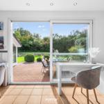 Raum mit Schreibtisch, Sitzgelegenheit und Blick auf den Garten.