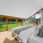 Schlafzimmer mit großem Fenster und Blick auf Garten