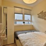 Schlafzimmer mit Bett, Fenster und Wanddekoration