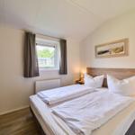 Schlafzimmer mit Doppelbett, Kleiderschrank und Fenster mit Blick.