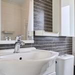 Waschbecken mit Spiegel und Toilette in Badezimmer