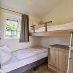 Zimmer mit zwei Betten, einem Schrank und einem Fenster.