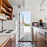 Kitchen with wooden shelves, refrigerator, and view of balcony