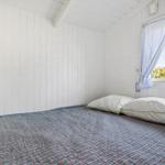 Bedroom with bed, white walls, and window with curtains.