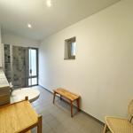 Badezimmer mit Dusche, Waschbecken und Holzbank.