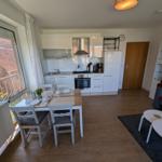 Küche mit Essbereich und Wohnbereich mit Sofa und Tischen.