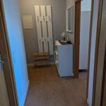 Flur mit Garderobe, Schuhschrank und Spiegel an der Wand.