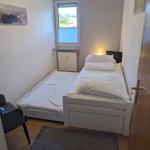 Ein Schlafzimmer mit einem Bett, einem Fenster und einem Teppich.