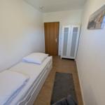 Schlafzimmer mit Bett, Kleiderschrank und Teppich