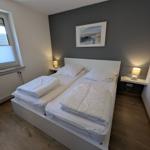 Schlafzimmer mit Doppelbett, zwei Nachttischen und Wandbild.