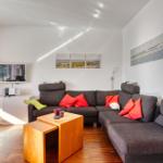 Wohnzimmer mit Sofa, Fernseher und Holztisch.