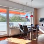 Esszimmer mit Balkon, TV und moderner Beleuchtung.